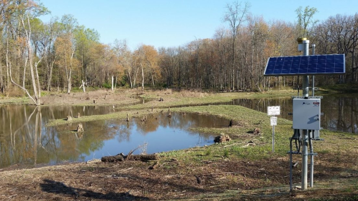 Solar-powered stormwater control equipment monitoring water levels in a natural basin