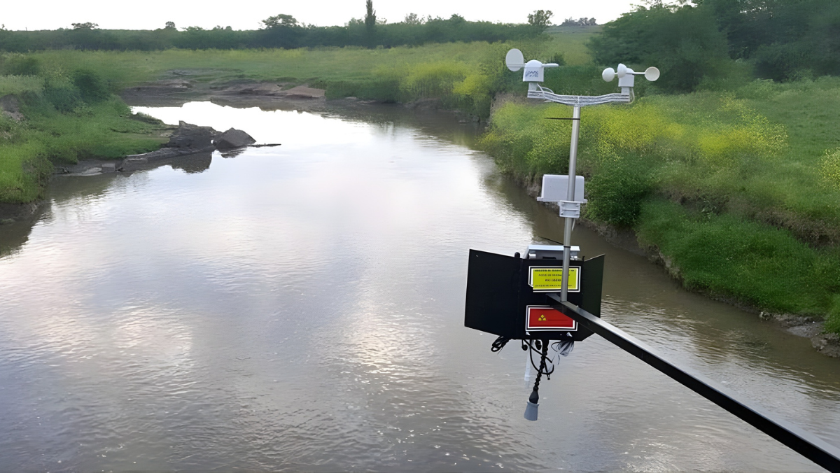 River monitoring station with weather and water level sensors installed above flowing water