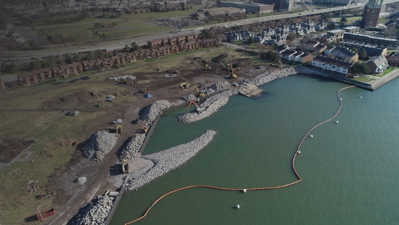 Aerial view of shoreline construction and stormwater works along a residential waterfront